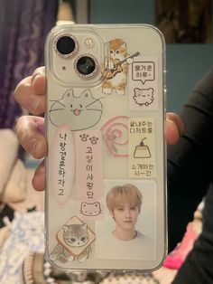 a person holding up a cell phone case with stickers on it and an image of a cat