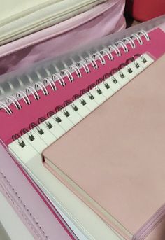 a pink and white binder sitting on top of a desk