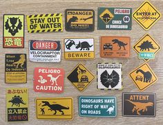 several different types of stickers on a wooden surface, including dinosaurs and dinosaurs