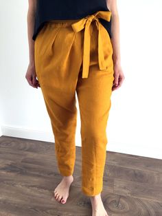 "Handmade 100% MaTuTu Linen Style trousers with pockets and belt. Made with love for You. *100% local medium weight linen *Each item is individually cut and sewn by order *The model is wearing size L, trousers color - mustard yellow *Note that colors may look different on your display depending on their settings and technical characteristics. Please let us know if you need different measurements or colors. CARE *Machine wash up to 40 / 104F gentle cycle *Iron inside out at medium high *Do not bl Linen Tie Waist Pants For Work, Workwear Linen Pants With Tie Waist, Linen Bottoms With Tie Waist For Work, Casual Linen Belted Bottoms, Belted Linen Bottoms For Spring, Mustard Summer Workwear Pants, Linen Paperbag Waist Pants For Workwear, Linen Paperbag Waist Pants For Summer, Yellow Linen Bottoms For Spring