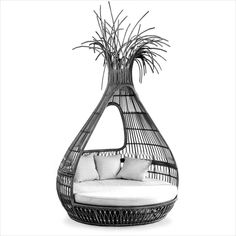 a black and white photo of a wicker hanging chair with pillows on the back