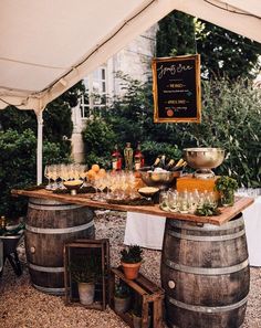 an image of a table with wine glasses and bottles on it in front of a tent