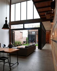 an open living room and dining area with large windows on the side of the building