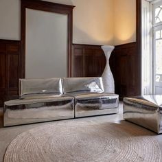 a silver couch and ottoman in a living room