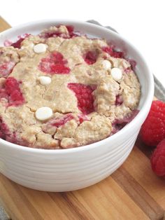 a bowl filled with oatmeal sitting on top of a wooden cutting board