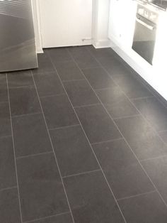 an empty kitchen with tile flooring and stainless steel appliances