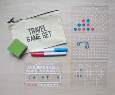 a travel game set with markers, pencils and eraser on a wooden table