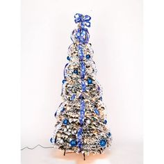 a small christmas tree with blue and white ornaments on it's base, in front of a white background