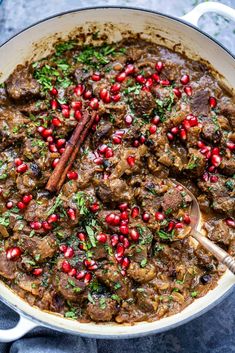 a pot filled with meat and pomegranates