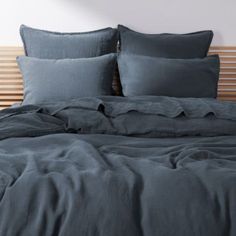 a bed with blue sheets and pillows on it