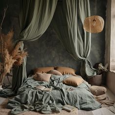 an unmade bed with green drapes and pillows