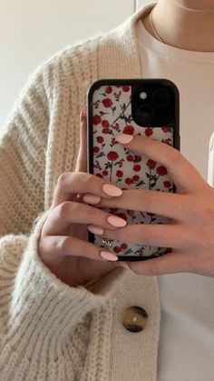 a woman is holding her cell phone with flowers on it