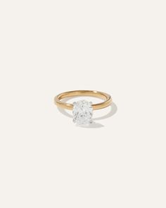 a gold ring with an oval white diamond