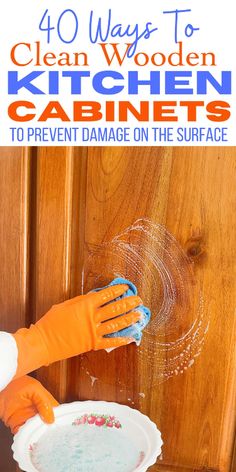 a person in an orange glove is cleaning a kitchen cabinet