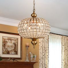 a chandelier hanging from the ceiling in a living room next to a fireplace