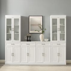 a white china cabinet with wine glasses on top