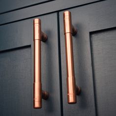 two metal handles on a blue cabinet door