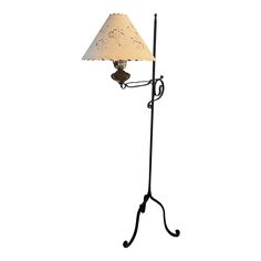 a lamp that is on top of a metal stand with a light shade over it