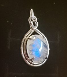 Very Nice Blue Flash Moonstone set in Beautiful Celtic Inspired 925 Sterling Pendant. Stone is approx 12x16mm. Some Defects and Lines are Naturally Occurring in Moonstones. I Have Multiple Stone Options By Availability. See Photos. Great Gift! Gift Box Shown Included. Oval Silver Moonstone Gemstones, Silver Oval Moonstone Jewelry, Silver Moonstone Pendant Gemstones, Oval Moonstone Wire Wrapped Necklaces, Oval Moonstone Necklace Wire Wrapped, Moonstone Gemstone Jewelry In Oval Cabochon, Sterling Silver Jewelry With Oval Cabochon Natural Stones, Silver Moonstone Gemstones For Healing, Oval Moonstone Jewelry With Natural Stones