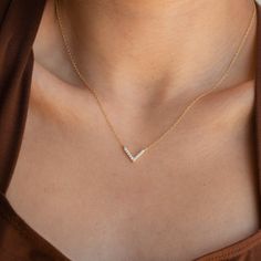 Our Pave Diamond Chevron Necklace is a one-and-done piece with an emphasis on elegance. With a classy yet subtle touch, the dainty V shaped charm hangs delicately on a minimal chain for the perfect finish to an effortlessly chic look. Material: High Quality Solid 925 Sterling Silver Finish: Sterling Silver ∙ 18K Gold Featuring 12mm Pave CZ Diamond Charm with adjustable chain 16 inches to 18 inches SKU: RR-NR080 Jewelry Hacks, Sideways Initial Necklace, Dainty Initial Necklace, Diamond Huggies, Mama Necklace, Art Deco Diamond Rings, Best Friend Necklaces, Birthday Gifts For Best Friend