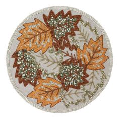 an orange and green leaf design on a white background is featured in this round rug