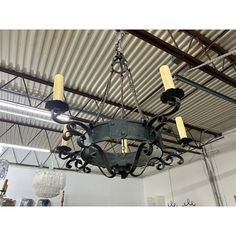 a chandelier hanging from the ceiling in a room with metal beams and lights