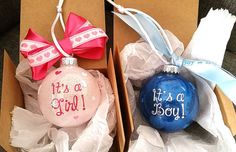 two christmas ornaments in boxes with bows on them, one is pink and the other is blue