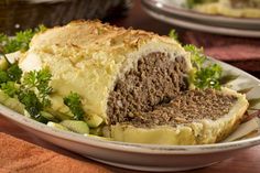 a meatloaf sandwich on a plate with bread and vegetables