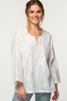 "Our Tara Tunic is hand embroidered by women artisans in Northern India in the shadow-work style known as \"Chikankari\". Chikankari is a delicate and artfully done hand embroidery technique that women in this region have been doing for generations.  Available in two sizes, S/M and L/XL, this beautiful 100% cotton tunic is designed for a comfortable and elegant fit." Luxury Chikankari Embroidered Tops For Party, Luxury Bollywood Tops With Chikankari Embroidery, Transitional Tops With Resham Embroidery, Casual Embroidered Top With Chikankari, Bohemian Chikankari Embroidered Tunic Top, Floral Embroidered Kurta For Summer, Traditional White Chikankari Embroidered Top, Spring Cotton Embroidered Top With Chikankari, White Cotton Blouse With Tonal Embroidery