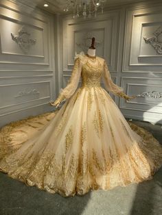 a dress on display in a room with white walls and chandelier hanging from the ceiling