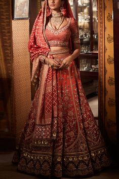 a woman in a red and gold bridal gown