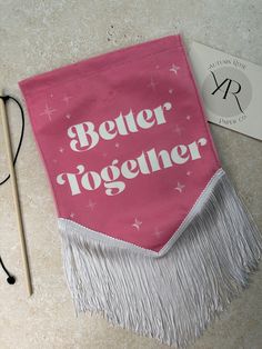 a pink bag with the words better together printed on it next to a pair of knitting needles