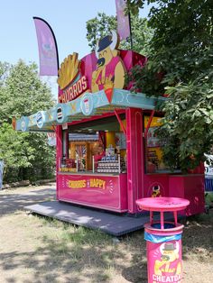 a pink food stand sitting on top of a lush green field