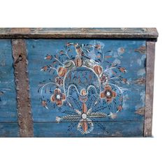 an old blue painted chest with flowers and birds on it