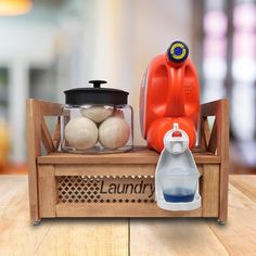 an orange juicer sitting on top of a wooden table next to two jugs