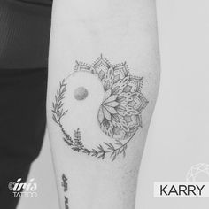 a woman's arm with a tattoo on it that has an image of a flower in the center