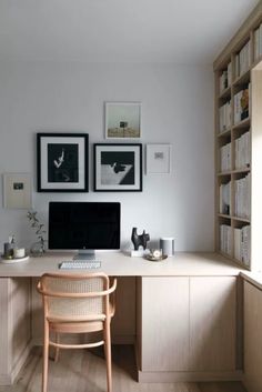 a desk with a computer on top of it in front of some bookshelves