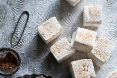 several pieces of white cake sitting on top of a table next to a strainer