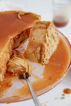 a piece of cake on a plate with caramel sauce and a fork in it