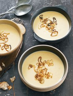 three bowls filled with soup on top of a table