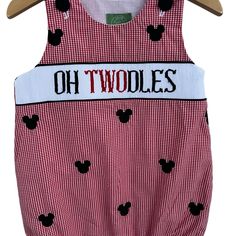 a red and white dress with mickey mouse patches on the chest, which reads oh twoddles