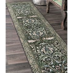 a green rug with an ornate design on the floor