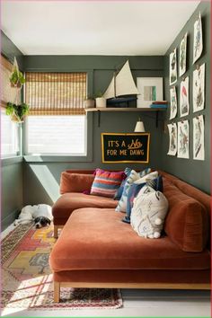 a living room with green walls and pictures on the wall above the couch is a dog sleeping on the floor