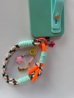 an orange and green lanyard attached to a blue case with star charms on it