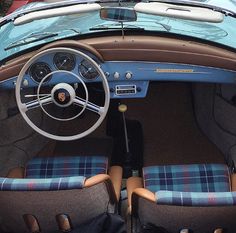 the interior of a sports car with blue and brown plaid upholstered seats, steering wheel and dashboard