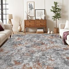 a living room with white couches and an area rug that has faded paint on it