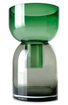 a green glass vase sitting on top of a white table