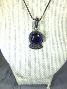 Sterling and amethyst pendant necklace. Round amethyst stone in a simple sterling setting with a decorative bale. Marked 925. Pendant hangs from a 17'' braided sterling chain with lobster clasp. Please check the pics carefully as they are part of the description. All of my items are vintage and I try to mention any flaws I find.  I leave the cleaning and polishing to the buyer as some prefer the pieces in their found condition. If you have any questions about the piece Please convo me and I  wil Silver Amethyst Cabochon Necklace, Silver Amethyst Necklace With Cabochon, Hallmarked Amethyst Round Pendant Necklace, Amethyst Cabochon Necklace For Gift, Purple Oxidized Jewelry For Gift, Amethyst Pendant Necklace, Amethyst Necklace Pendant, Amethyst Pendant, Amethyst Stone