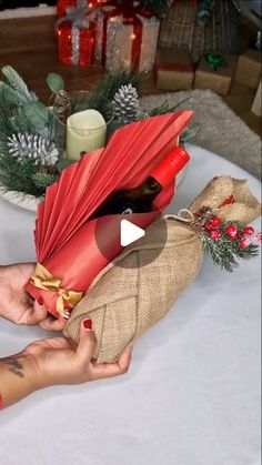 a person holding a red umbrella over a table with christmas decorations and candles in the background