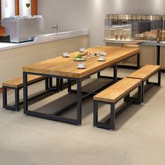 a wooden table with benches in front of it and some food on the counter top